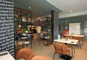 Modern lodge dining area with brown chairs, white tables, black-and-white columns, and decorations.