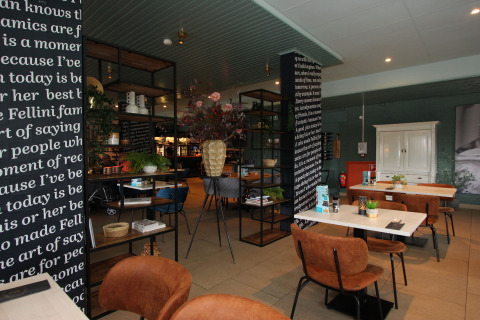 Modern lodge dining area with brown chairs, white tables, black-and-white columns, and decorations.