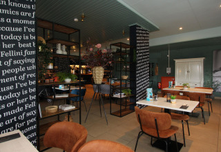 Modern lodge dining area with brown chairs, white tables, black-and-white columns, and decorations.
