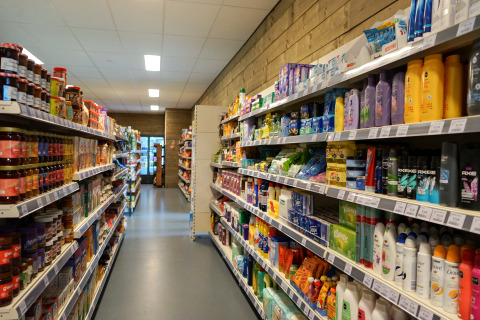 Photo d'une allée dans une boutique d’un lodge, avec des rayons de nourriture et de soins personnels.