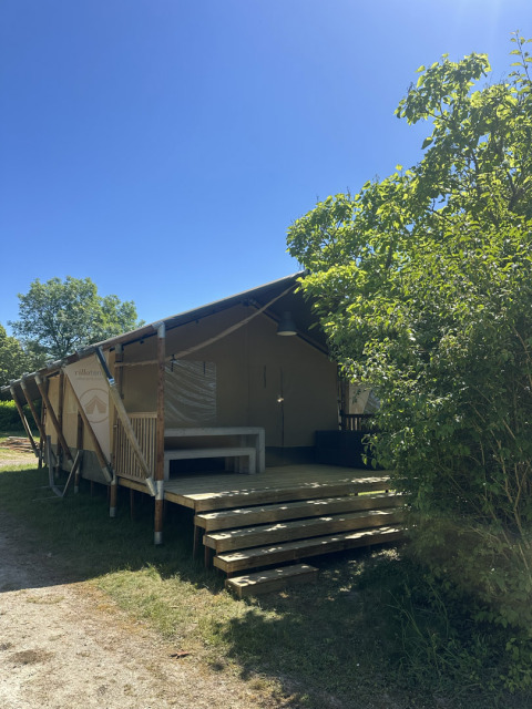 La tenda safari Villatent Nomad al campeggio Les Bois du Bardelet in Francia, immersa nella natura verde.