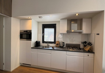 Moderne keuken in ‘Cannenburch’ Deluxe lodge, Veluwe park de Bosgraaf, met raam en keukenapparaten.