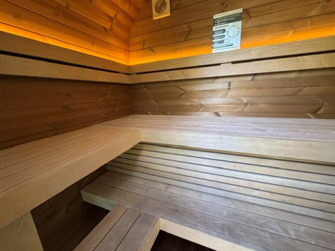 Binnenzicht van een moderne houten sauna met sfeerverlichting in Cannenburch Deluxe, Veluwe park de Bosgraaf.