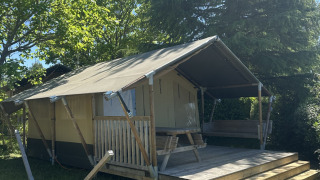 Safaritent genaamd Compact met privé sanitaire voorzieningen, houten terras en picknicktafel buiten.
