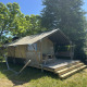 Safari-telt kaldet Compact med private sanitære faciliteter, træterrasse og picnicbord i naturen.