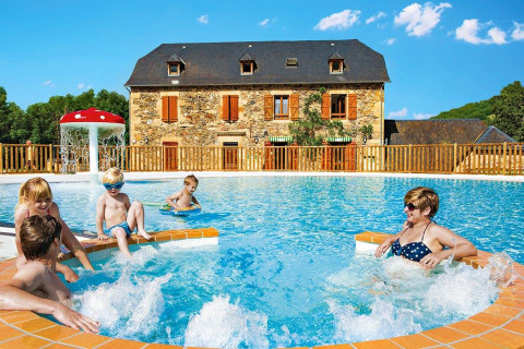 Famiglia che si gode la piscina al Seasonova Camping Les Rives d'Olt et Aubrac in Occitania, Francia.