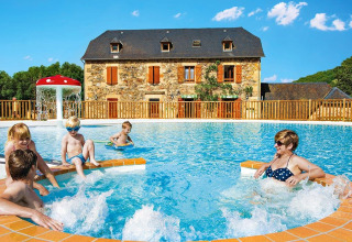 Famille profitant de la piscine au Seasonova Camping Les Rives d'Olt et Aubrac en Occitanie, France.