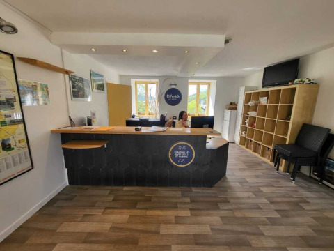 Reception area at Seasonova Camping Les Rives d'Olt et Aubrac holiday park in Occitanie, France, with staff.