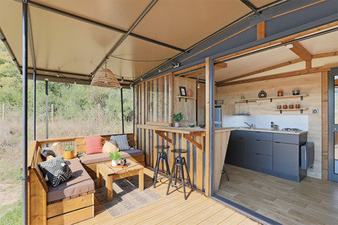 Casa tiny moderna al Seasonova Camping Les Rives d'Olt et Aubrac in Francia con terrazza e cucina aperta.