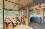 Casa tiny moderna al Seasonova Camping Les Rives d'Olt et Aubrac in Francia con terrazza e cucina aperta.