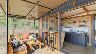Casa tiny moderna al Seasonova Camping Les Rives d'Olt et Aubrac in Francia con terrazza e cucina aperta.