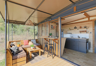 Casa tiny moderna al Seasonova Camping Les Rives d'Olt et Aubrac in Francia con terrazza e cucina aperta.
