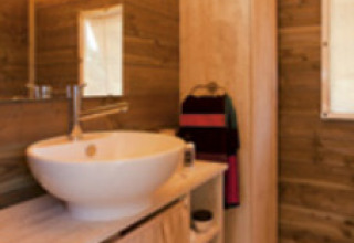 Badezimmer im Lodge Confort Safarizelt bei Seasonova Camping Les Rives d'Olt et Aubrac in Frankreich.