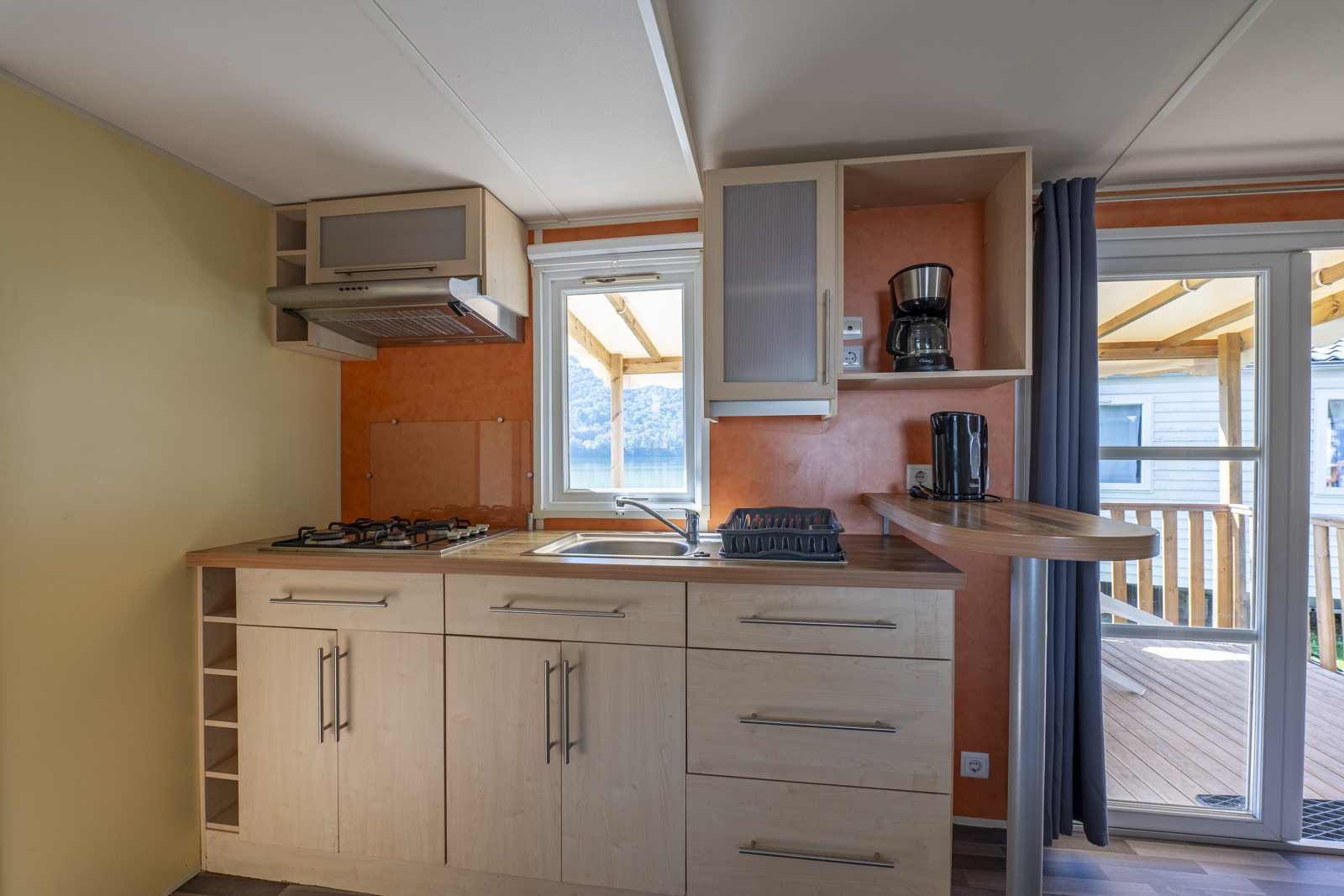 Moderne kitchenette in Classic Mobile Home op Camping Seasonova Sous le Moulin, Frankrijk, met terrasuitgang.