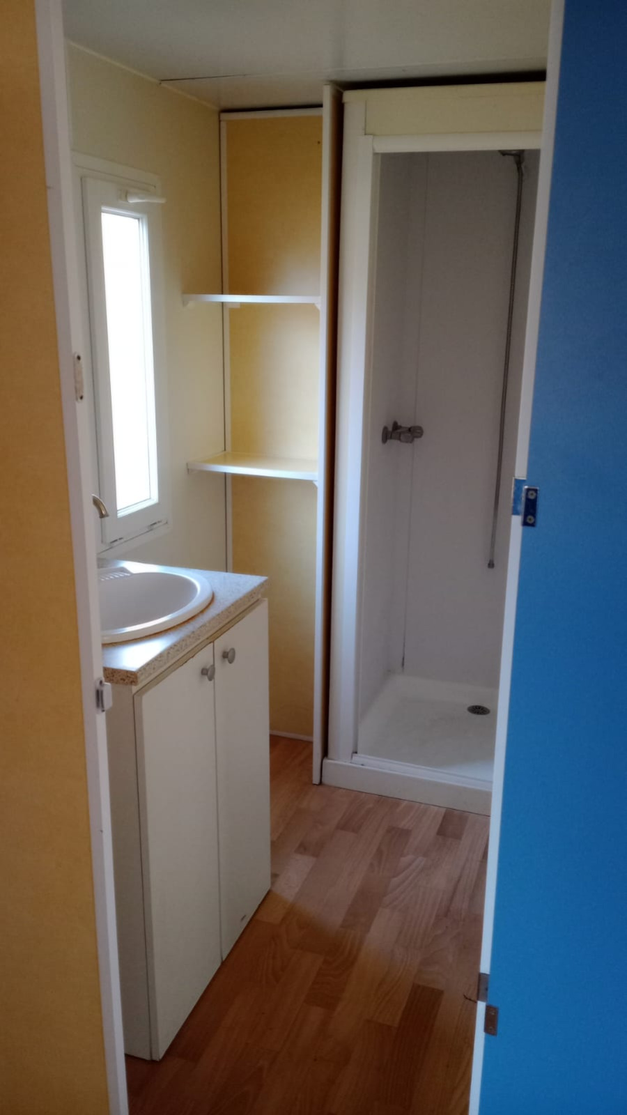 Badkamer in Mobile Home Eco bij Camping Seasonova Sous le Moulin met douche en wastafel.