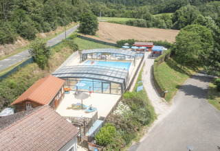 Aerial view of Seasonova Camping Le Val de Coise showing covered pool, countryside, and holiday park in France.