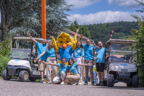 Staff group at Seasonova Camping Le Val de Coise, Pays de la Loire, France, posing between two golf carts.