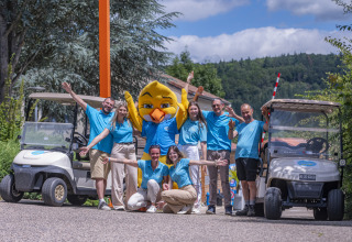 Personal de Seasonova Camping Le Val de Coise en Pays de la Loire, Francia, posando entre carritos de golf.