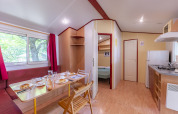 Interno della Mobile Home Eco al Seasonova Camping Le Val de Coise in Francia, con sala da pranzo e cucina.