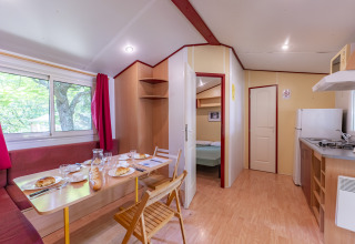 Innenansicht des Mobile Home Eco im Seasonova Camping Le Val de Coise Frankreich mit Küche und Essbereich.