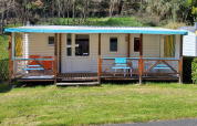 Casa mobile Eco al Seasonova Camping Le Val de Coise in Francia con veranda coperta e zona salotto esterna.