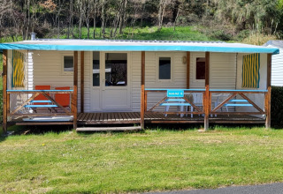 Mobilheim Eco bei Seasonova Camping Le Val de Coise mit überdachter Veranda und Gartenmöbeln in Frankreich.