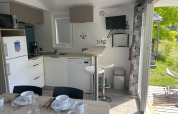 Vista interna della Comfort+ mobile home al Seasonova Camping Le Val de Coise, Francia, con cucina completa.