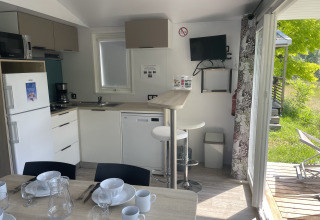 Vista interna della Comfort+ mobile home al Seasonova Camping Le Val de Coise, Francia, con cucina completa.