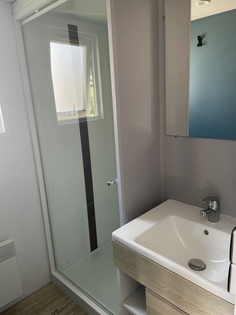 Bagno nella casa mobile Comfort+ al Seasonova Camping Le Val de Coise con doccia e lavandino.