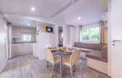 Interno moderno e luminoso di una casa mobile Premium con cucina e zona pranzo al Seasonova Camping Le Val de Coise.