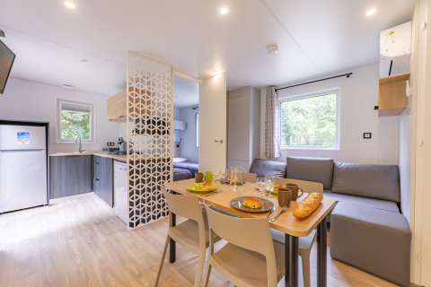 Casa móvil premium moderna en Seasonova Camping Le Val de Coise, con cocina, comedor y zona de estar.