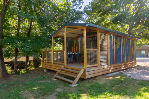 Cabaña Cottage Comfort entre árboles, con terraza de madera y un entorno natural tranquilo y relajante.