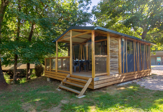 Cabaña Cottage Comfort entre árboles, con terraza de madera y un entorno natural tranquilo y relajante.