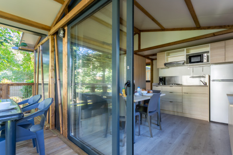 Vista interior y exterior de la cabaña Cottage Comfort en Camping Paradis Le Giessen en Francia.