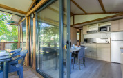 Udendørs og indendørs udsigt til hytte Cottage Comfort på Camping Paradis Le Giessen i Frankrig.