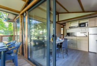 Vista interior y exterior de la cabaña Cottage Comfort en Camping Paradis Le Giessen en Francia.