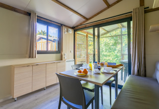 Spiseområde i Cottage Comfort, Camping Paradis Le Giessen, Frankrig, med udsigt til naturen.