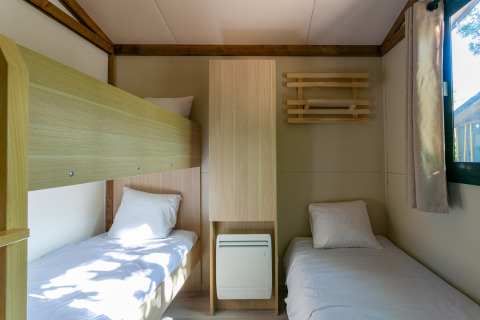 Habitación moderna en Cottage Comfort, Camping Paradis Le Giessen, con literas y camas individuales.