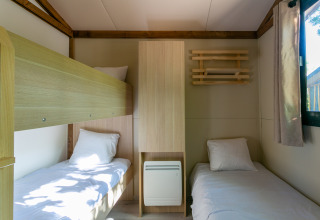 Habitación moderna en Cottage Comfort, Camping Paradis Le Giessen, con literas y camas individuales.
