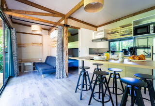 Vista interior de Cottage Premium en Camping Paradis Le Giessen, Francia, mostrando cocina y comedor acogedor.