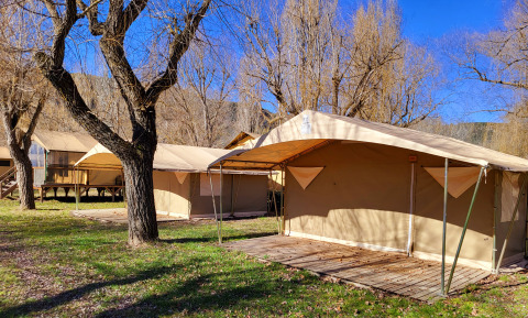 Safari-telte ved Eco Lodge på Seasonova Camping Les Prés du Verdon i Frankrig under klare blå himmel.