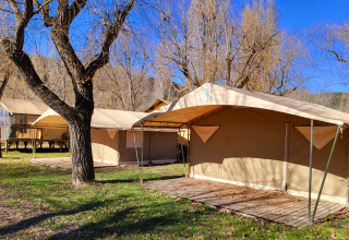 Safaritenten van de Eco Lodge op Seasonova Camping Les Prés du Verdon in Frankrijk, onder blauwe hemel.