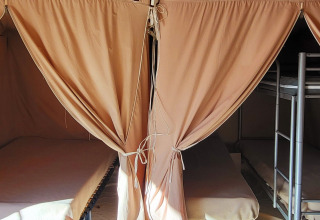 Indvendig udsigt af en safariteltsuite med enkeltsenge og køjesenge ved Seasonova Camping Les Prés du Verdon.