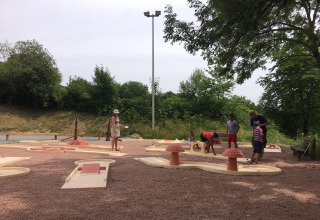 Des familles jouent au mini-golf en plein air au Camping Paradis Les Chanterelles en Auvergne-Rhône-Alpes, France.