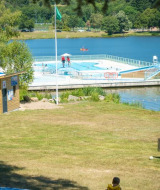 Piscina galleggiante sul lago a Camping Paradis Les Chanterelles, Auvergne-Rhône-Alpes, Francia.