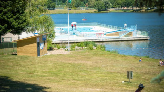 Piscina galleggiante sul lago a Camping Paradis Les Chanterelles, Auvergne-Rhône-Alpes, Francia.