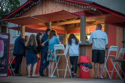 Folk står i kø ved en udendørs kiosk på Camping Paradis Les Chanterelles i Auvergne-Rhône-Alpes, Frankrig.