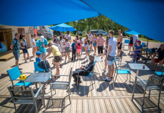 Familier og børn nyder solen og sociale aktiviteter på Camping Paradis Les Chanterelles i Frankrig.