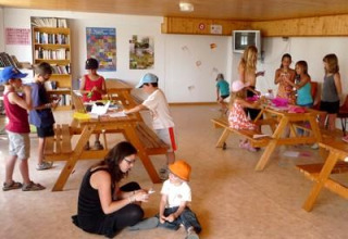 Niños y adultos participan en actividades de manualidades y ocio en el Camping Paradis Les Chanterelles, Francia.