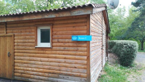 Vista esterna di un lodge in legno chiamato Roses 2 al Chalet Eco, Camping Paradis Les Chanterelles in Francia.